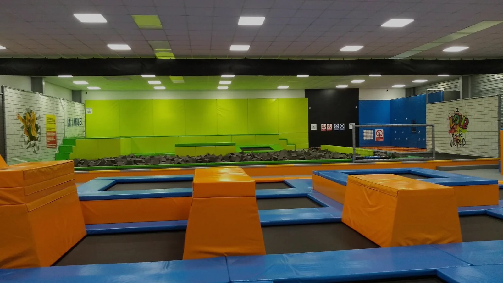 Intérieur d'un trampoline park New Jump : zone de saut libre, fosse à mousse et modules